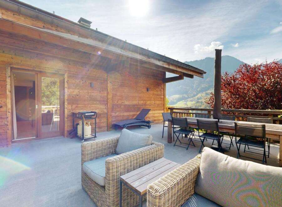 Enjoy stunning mountain views from this spacious wooden chalet's outdoor patio, perfect for al fresco dining or relaxing.