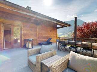 Enjoy stunning mountain views from this spacious wooden chalet's outdoor patio, perfect for al fresco dining or relaxing.