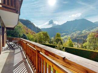 Enjoy breathtaking mountain views from the private balcony of this charming wooden chalet.