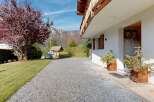 Experience the charm of this alpine property, featuring a welcoming entrance with rustic wooden shutters and planters.