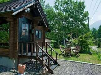 Escape to this charming log cabin nestled amidst lush greenery, offering a serene retreat.