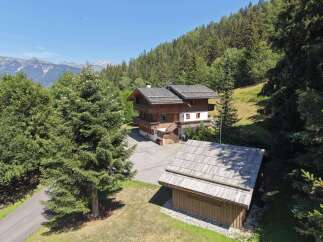 Nestled amidst a lush green forest and offering breathtaking mountain views, this charming wooden chalet is an idyllic retreat.