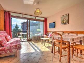 Enjoy stunning mountain views from this charming living area, featuring a comfortable sofa bed and a dining table perfect for family meals.