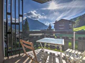 Enjoy breathtaking mountain views from this charming balcony, complete with a table and chairs for al fresco dining.