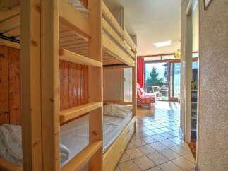 This cozy mountain retreat features a charming wooden bunk bed area, perfect for families or groups.