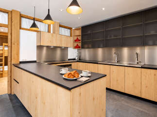 Experience modern living in this stunning kitchen, featuring sleek black cabinetry and warm wood accents.