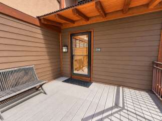 Welcome to this charming property featuring a welcoming porch with a wooden bench, perfect for enjoying the outdoors.