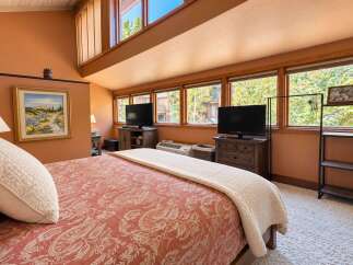 This charming bedroom features a cozy bed with a patterned comforter and a plush white throw.