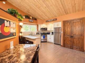 Step into a charming kitchen featuring a vaulted wood-paneled ceiling and warm orange walls.