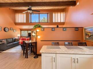 Experience the warmth of this inviting living space, featuring a spacious living room with a comfortable leather sofa and a cozy dining area perfect for intimate meals.