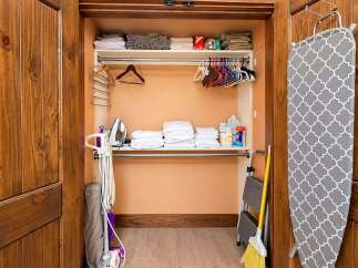Discover the convenience of this well-organized laundry closet, featuring ample shelving for linens and cleaning supplies.