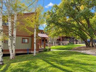 Experience the charm of autumn with this inviting property, featuring a warm brown and green exterior that complements the vibrant fall foliage.