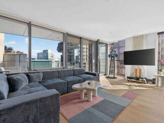 Experience modern luxury in this spacious living room, featuring a large sectional sofa perfect for relaxation and entertaining.