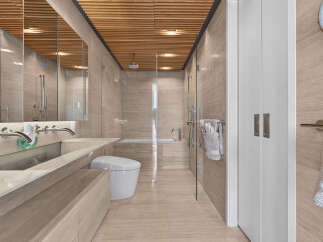 Experience modern luxury in this stunning bathroom, featuring a sleek floating vanity with dual vessel sinks and a wall-mounted soap dispenser.
