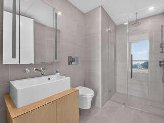 Experience modern luxury in this stunning bathroom featuring a sleek vanity with a vessel sink and wall-mounted faucets.
