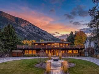 Experience luxury living in this stunning modern home nestled against a majestic mountain backdrop.