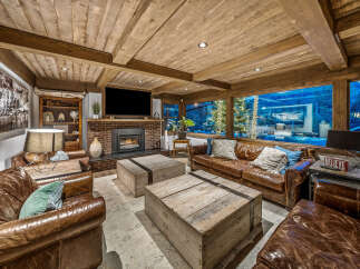 Experience rustic luxury in this inviting living room, featuring plush leather sofas and rustic wooden coffee tables.