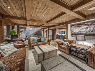 Experience rustic charm and modern comfort in this inviting living space, featuring rich leather sofas and unique wooden crate coffee tables.