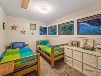 This charming bedroom features two twin beds with vibrant, colorful bedding, perfect for children or guests.