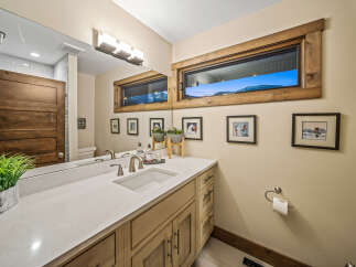 This modern bathroom features a sleek white countertop with an undermount sink and brushed nickel fixtures.