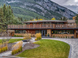 Experience luxury living in this stunning modern home, nestled against a majestic mountain backdrop.