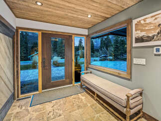 Step into this inviting entryway featuring a rustic wooden ceiling and stone tile flooring.
