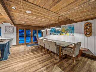 Experience elegant dining in this spacious room, featuring a long, rustic wooden ceiling and warm hardwood floors.