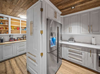 Experience the perfect blend of modern and rustic in this stunning kitchen, featuring sleek grey cabinetry with elegant gold hardware.