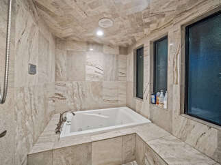 Indulge in luxury with this stunning bathroom featuring a spacious built-in jacuzzi tub, perfect for ultimate relaxation.