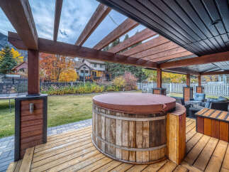 Experience ultimate relaxation in this backyard oasis, featuring a rustic wooden hot tub perfect for unwinding.