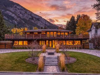 Experience luxury living in this stunning modern home, nestled against a majestic mountain backdrop.