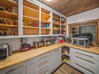 This spacious pantry offers ample storage with its floor-to-ceiling shelving, perfect for organizing all your kitchen essentials.