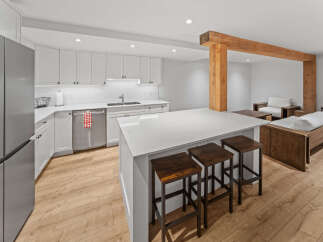 Experience modern living in this beautifully designed open-concept space, featuring a sleek white kitchen with ample cabinet storage and a spacious quartz island perfect for entertaining.