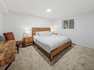 This inviting bedroom features a rustic wooden bed frame with a complementary headboard, creating a warm and cozy atmosphere.