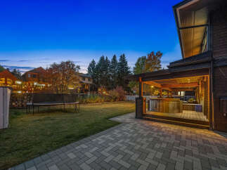 Experience outdoor living at its finest with this beautifully designed backyard, featuring a covered patio with a luxurious hot tub, perfect for relaxation.