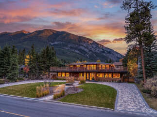 Experience luxury living in this stunning modern home nestled against a majestic mountain backdrop.