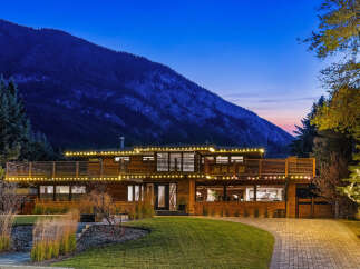 Experience luxury living in this stunning modern home, nestled against a majestic mountain backdrop.