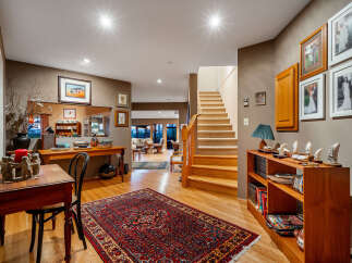 Step into a welcoming foyer featuring a grand staircase and warm hardwood floors.