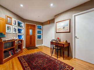 Step into this inviting entryway featuring a warm wooden door and elegant hardwood floors.