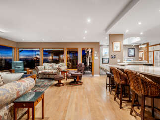Experience breathtaking sunset views from this spacious living area, featuring large windows that frame the stunning natural landscape.