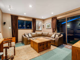 Relax in this cozy living room featuring a plush brown leather sectional sofa and a rustic wooden coffee table.