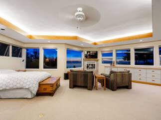 Experience breathtaking ocean views from this luxurious master suite, featuring a cozy fireplace and ample natural light.
