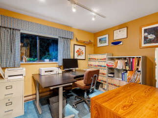 This home office features a large desk with a computer and printer, perfect for productivity.