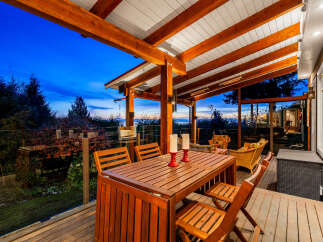 Experience breathtaking sunset views from this stunning covered deck, perfect for outdoor dining and relaxation.