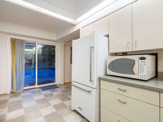 Step into this charming kitchen featuring a sleek white refrigerator and a convenient microwave.