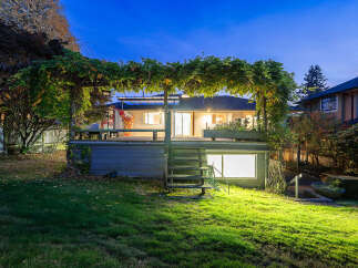 Enjoy evenings on this expansive deck, shaded by a lush vine-covered pergola, perfect for outdoor entertaining.