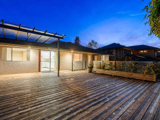 Step outside onto a spacious wooden deck, perfect for entertaining or relaxing in the evening.