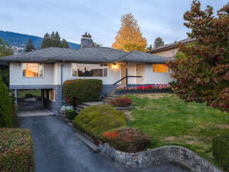 This charming home offers a unique split-level design with a covered carport and an attached garage, perfect for modern living.