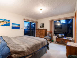 Experience breathtaking views from this bedroom, featuring large windows that showcase the serene natural surroundings.