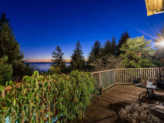 Enjoy breathtaking sunset views from this expansive wooden deck, perfect for outdoor entertaining or quiet relaxation.